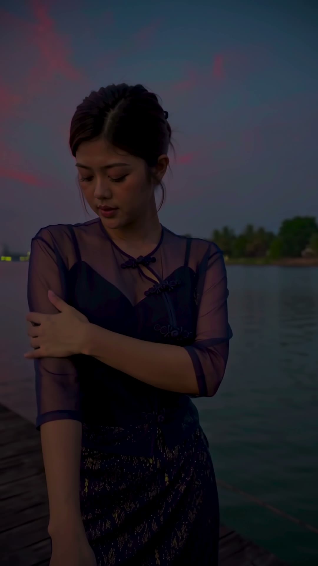 Navy sheer blouse at dusk on a wooden jetty, city lights across the lake