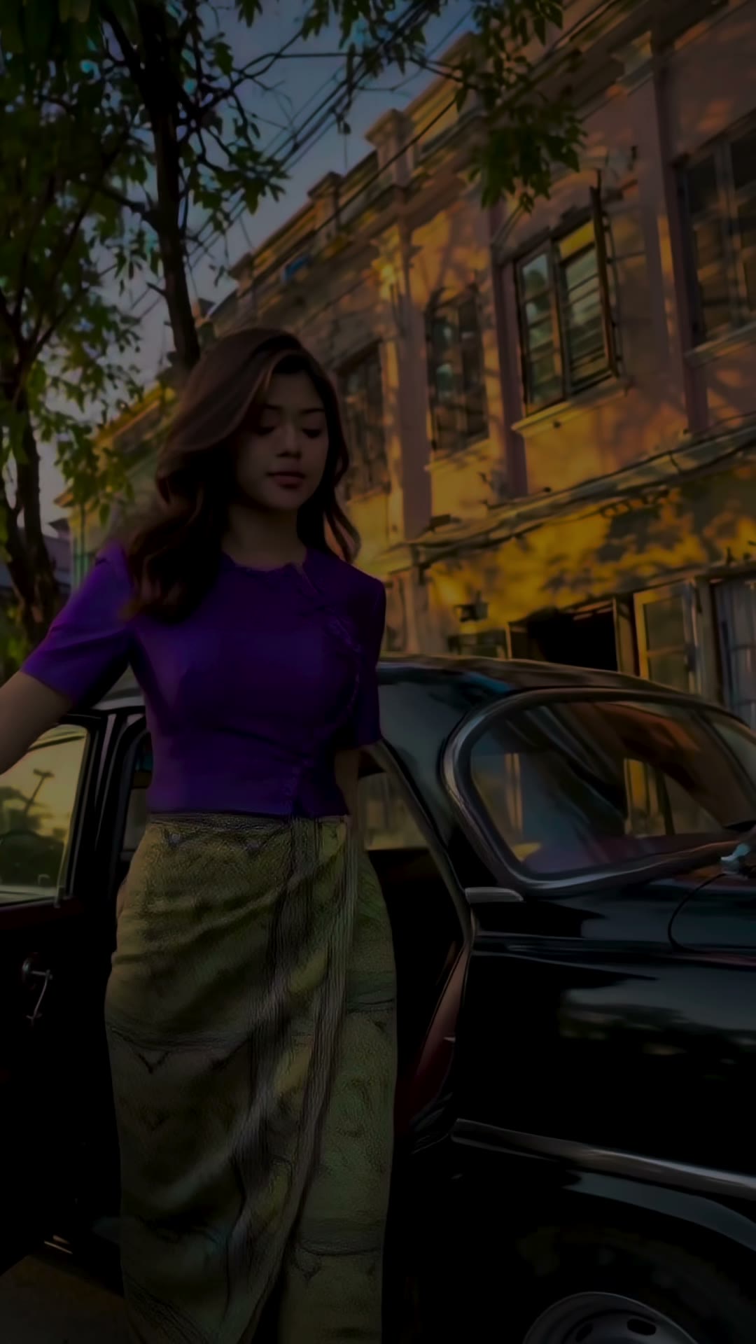Purple eingyi blouse and gold htamein, walking past a vintage black car on a colonial Yangon street